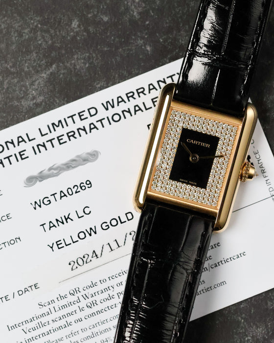 Cartier Tank LC placed over warranty card showing model and date details.
