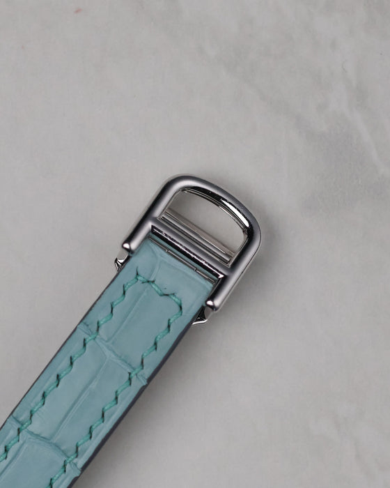 Cartier white gold deployant buckle attached to a light blue leather strap for the Tonneau WE400731.