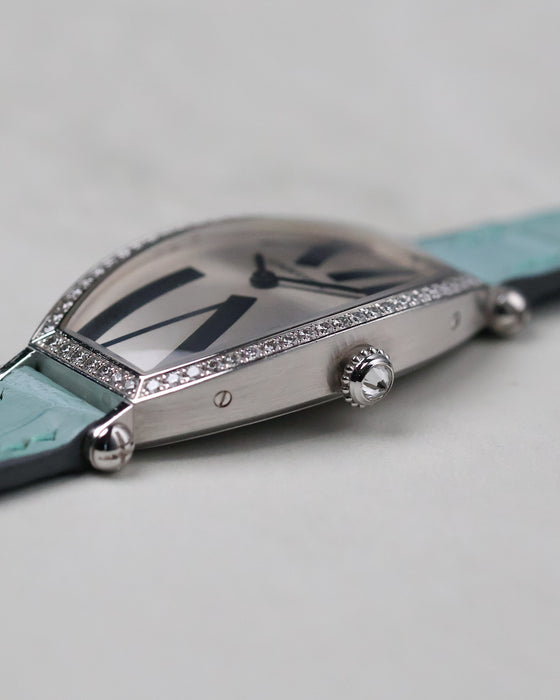 Side profile of the Cartier Tonneau WE400731 showing the brushed white gold case and diamond crown.