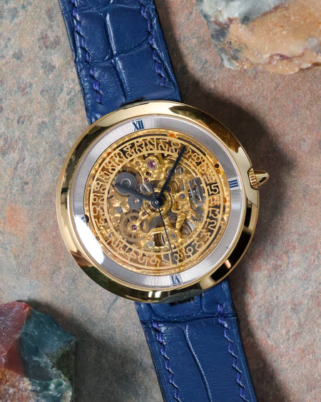 Front view of the Chaumet Pebble 13A skeleton dial with blue Roman chapter ring and blue leather strap.