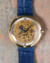 Straight-on view of the Chaumet Pebble 13A displaying the skeletonised dial and polished yellow gold case.