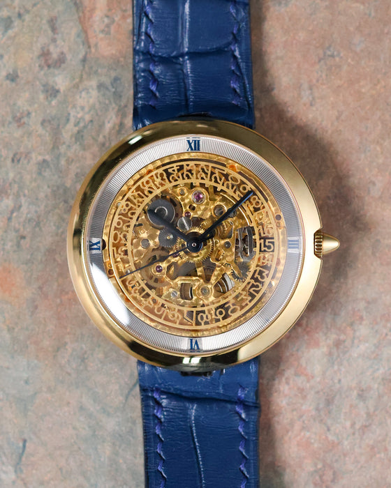 Straight-on view of the Chaumet Pebble 13A displaying the skeletonised dial and polished yellow gold case.