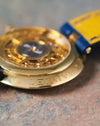 Macro side view of the Chaumet Pebble 13A showing the engraved 18k yellow gold caseback edge and open case back.