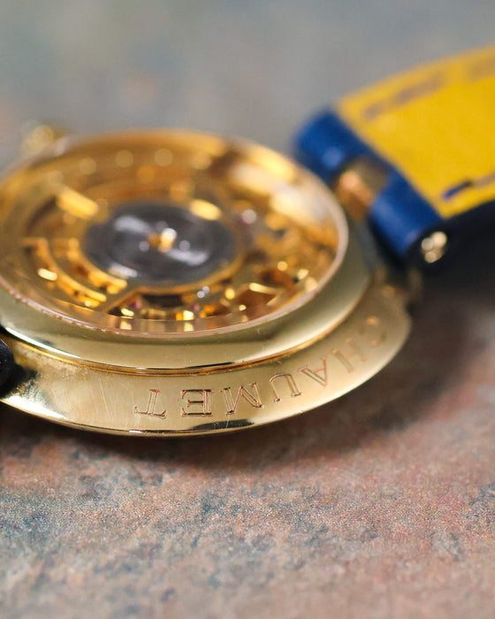 Macro side view of the Chaumet Pebble 13A showing the engraved 18k yellow gold caseback edge and open case back.