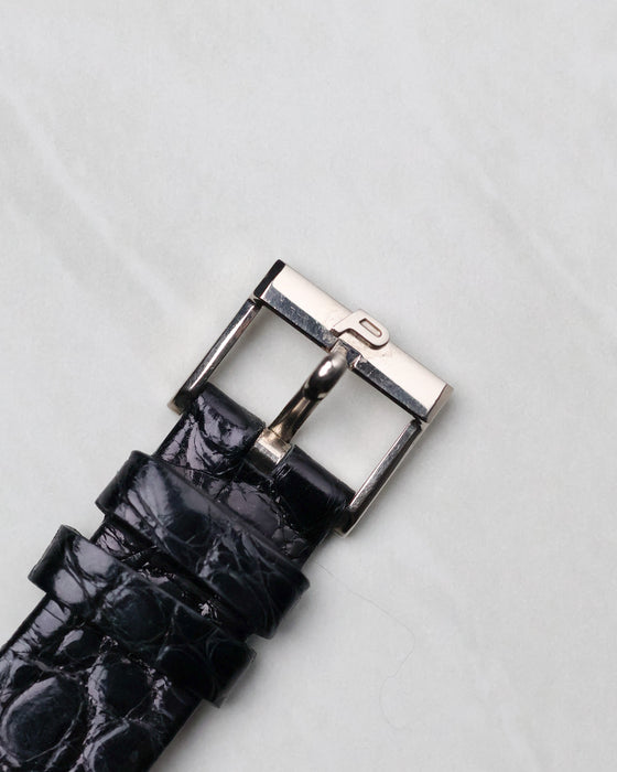 Original white gold Piaget buckle fitted to a black leather strap.