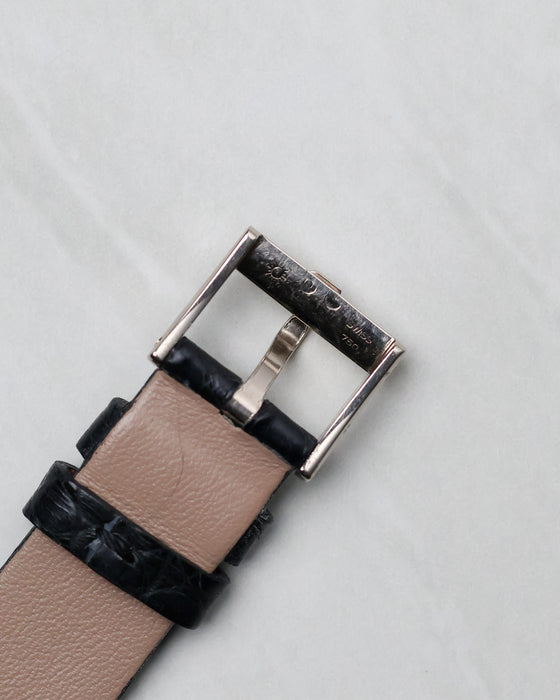 Reverse view of the Piaget signed white gold buckle on a black leather strap.