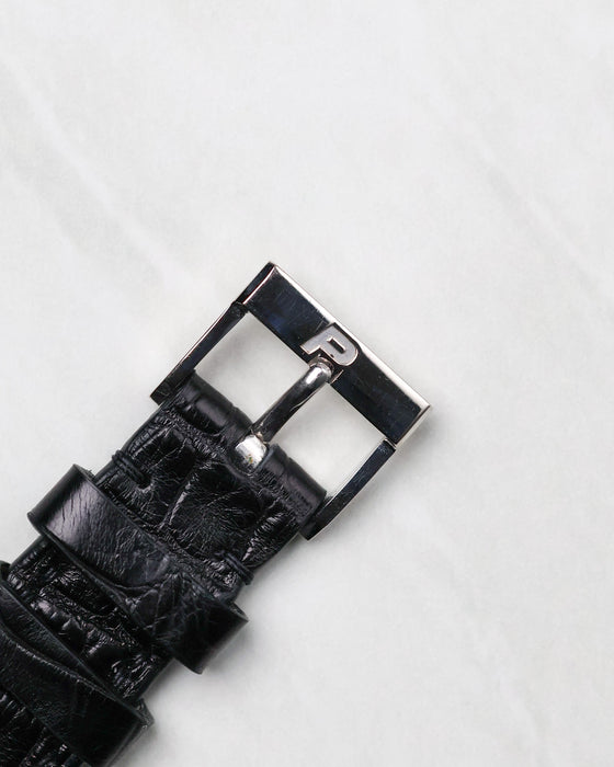 Original Piaget white gold pin buckle fitted to a black leather strap.