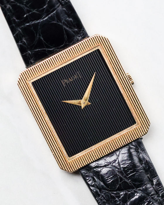 Front three-quarter view of the Piaget Protocole Ref. 8154 with black onyx tapestry dial and ribbed gold bezel.