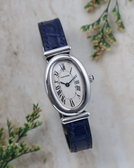 Front view of the Cartier Baignoire Biplan ref. 2295 with silver guilloché dial, Roman numerals and blued hands.