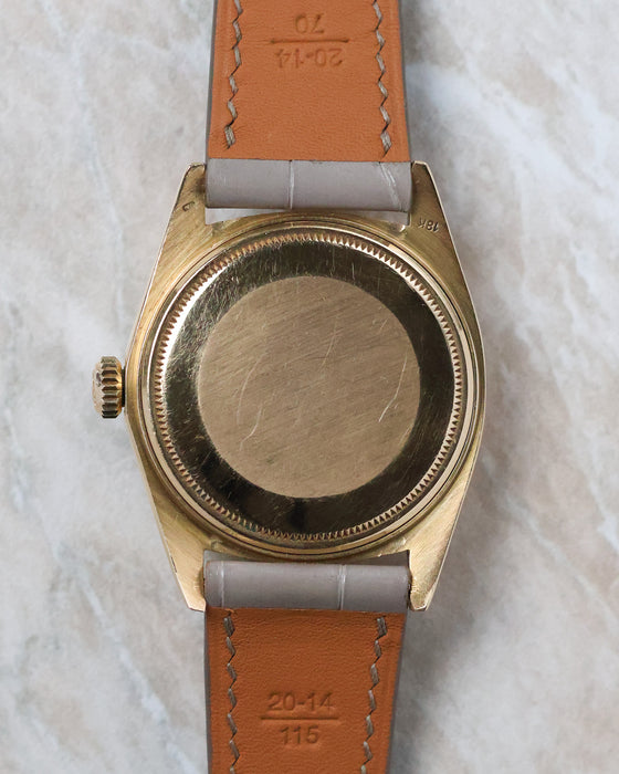 Caseback view of the Rolex Day-Date 1803 in yellow gold fitted to a grey leather strap.