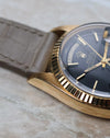 Macro detail of the Rolex Day-Date 1803 lug and fluted bezel in yellow gold.