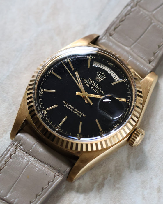 Macro detail of the Rolex Day-Date 1803 crystal edge and fluted yellow gold bezel.