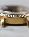 Macro side view of the Rolex Day-Date 1803 showing the serial engraving between the lugs and fluted yellow gold bezel.