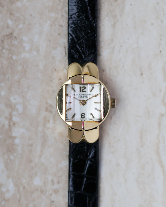 Patek Philippe Ref. 3017 yellow gold ladies watch with white dial photographed from directly above.