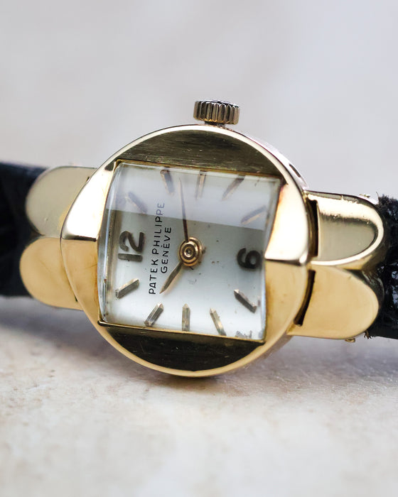 Patek Philippe Ref. 3017 yellow gold ladies watch showing the pagoda crystal and white dial from an angled front view.