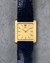 Vintage Girard-Perregaux rectangular watch in 18K yellow gold with gilt dial and blue leather strap.