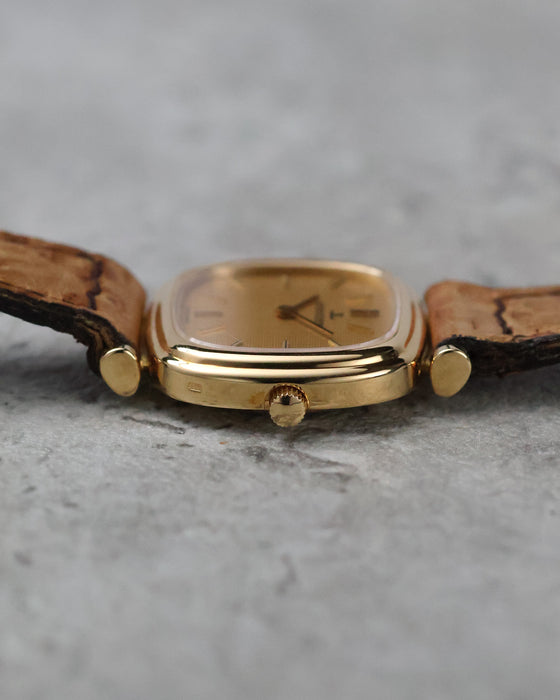 Low front profile highlighting the curved crystal, polished bezel and slim cushion-shaped case.