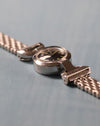 Side profile showing the domed crystal, stainless steel case and articulated lug construction.