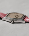 Side profile centred on the signed cabochon crown, showing the slim manual-wind case and polished white gold finish.