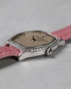 Crown-side view highlighting the flowing tonneau case and diamond setting.