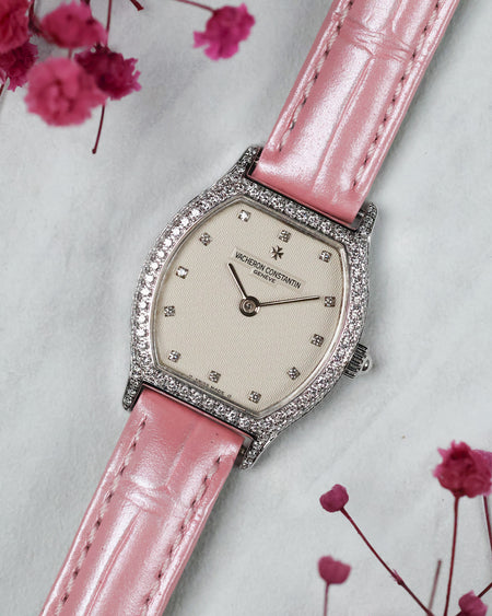 Full three-quarter composition of the Vacheron Constantin Ref. 10550 with its factory diamond-set case, guilloché dial and pink leather strap.