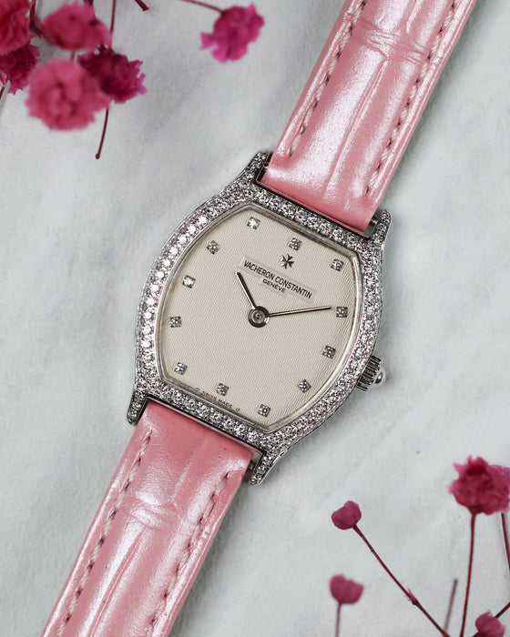 Full three-quarter composition of the Vacheron Constantin Ref. 10550 with its factory diamond-set case, guilloché dial and pink leather strap.