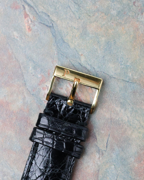 Original Piaget signed 18k yellow gold pin buckle fitted to the black leather strap.