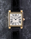 Front view of the Cartier Tank Obus Ref. 1630 with white Roman numeral dial, black enamel bezel and black leather strap.