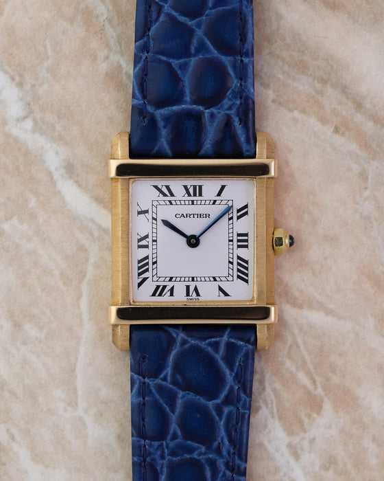 Front view of the Cartier Tank Chinoise Ref. 81051 in 18K yellow gold showing the white lacquer dial and blue leather strap.
