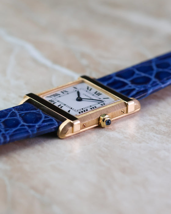 Side profile of the Cartier Tank Chinoise Ref. 81051 showing the brushed case, polished brancards and sapphire cabochon crown.