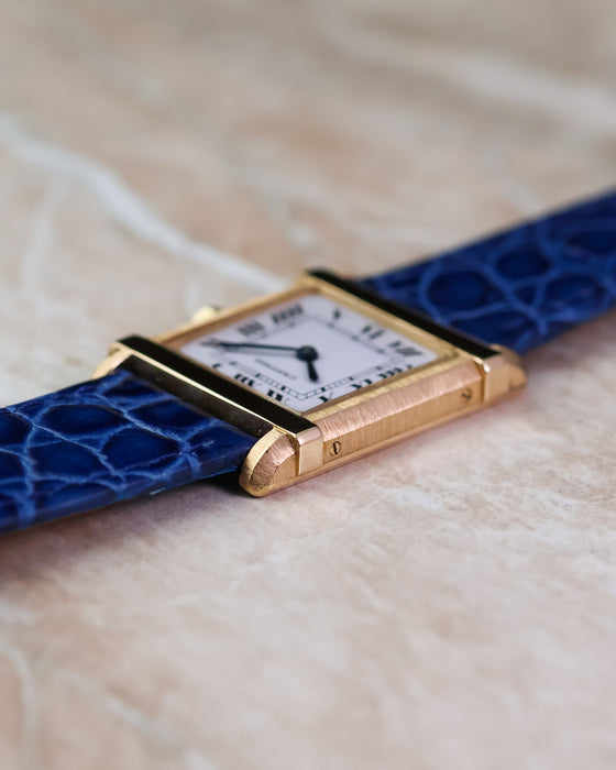 Side profile of the Cartier Tank Chinoise Ref. 81051 showing the brushed gold case and polished horizontal bars.