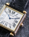 Macro photograph of the Cartier Tank Obus Ref. 1630 dial showing the Breguet hands, Roman numerals and black enamel bezel.