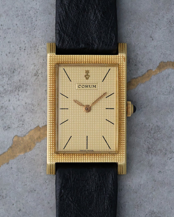 Front view of a vintage Corum Tank in 18K yellow gold with matching Clous de Paris dial and case.