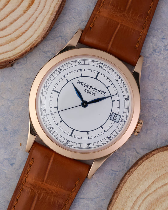 Angled front view showing the two-tone sector dial, date display and 18k rose gold case.