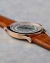 Side profile highlighting the polished bezel and flowing lug design of the 38mm rose gold case.