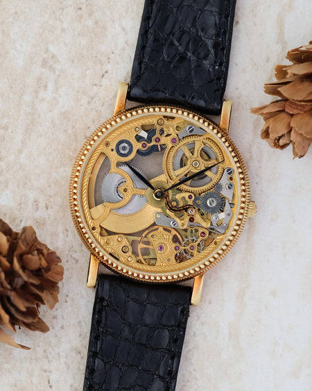 Universal Genève skeleton watch in 18K yellow gold with engraved openworked movement.