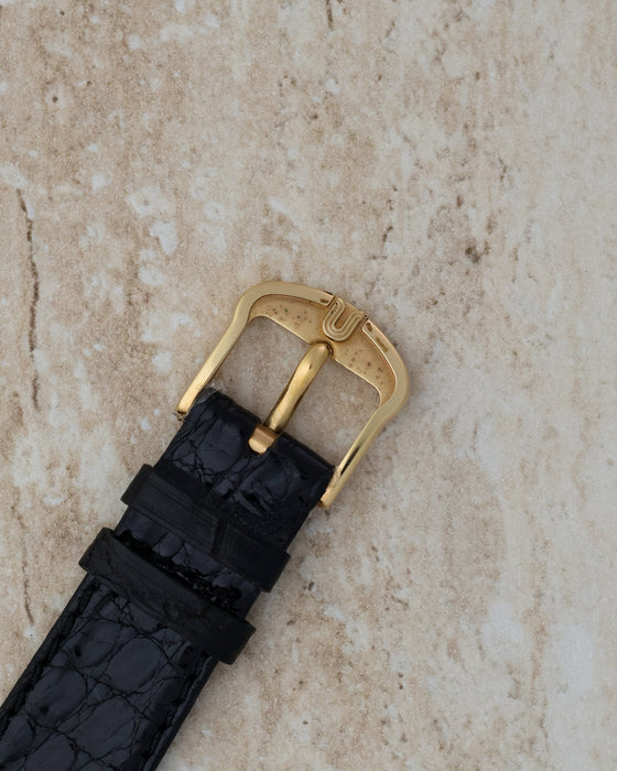 Side profile showing the finely fluted 18K yellow gold case and signed crown.