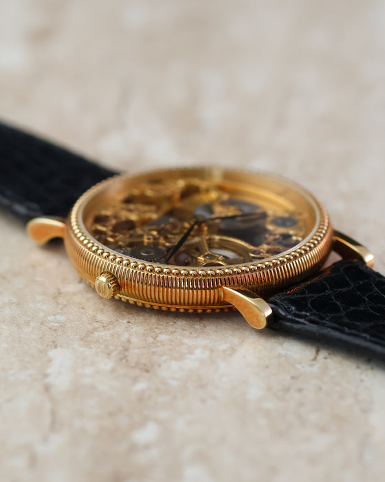 Angled view of the signed crown and detailed yellow gold case construction.