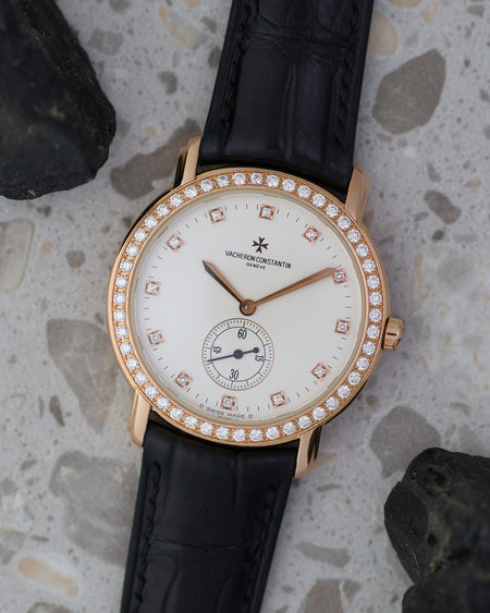 Vacheron Constantin Malte 81500 photographed with black stones, showing its pink-gold case, diamond bezel and small-seconds dial.