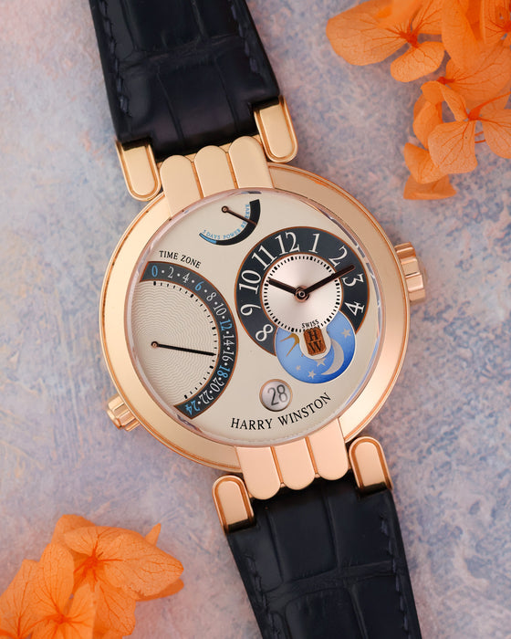 Angled view highlighting the silver dial, blue accents, day/night display and articulated rose gold lugs.
