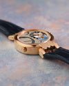 Side profile showing the polished rose gold case, articulated lugs and second-time-zone corrector.