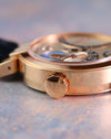 Close-up of the signed Harry Winston crown and polished 18K rose gold case.