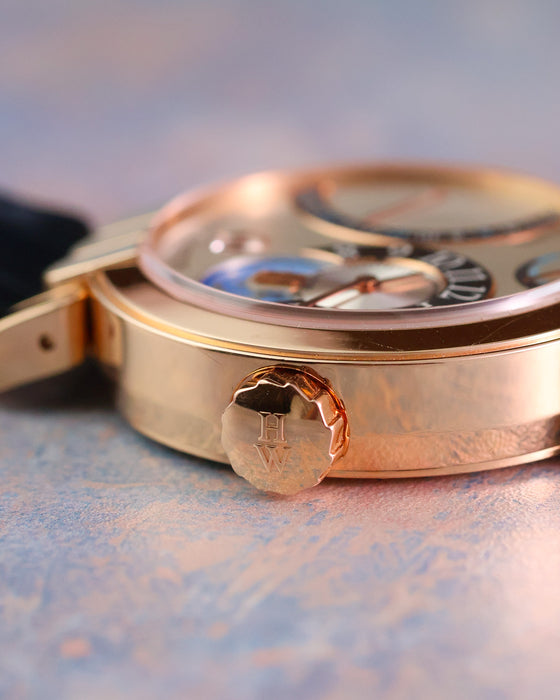 Close-up of the signed Harry Winston crown and polished 18K rose gold case.