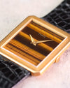 Close-up of the Piaget Protocole Ref. 9154 highlighting the natural tiger’s eye dial, dauphine hands and reeded gold bezel.