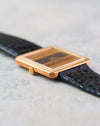 Side view showing the slim profile, reeded bezel and warm tones of the tiger’s eye dial.