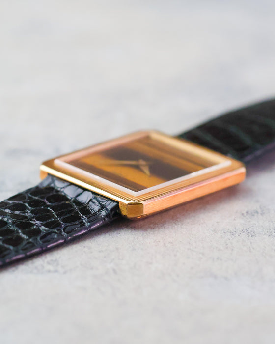 Side profile of the Piaget Protocole Ref. 9154 showing its slim 18K yellow gold case, reeded bezel and tiger’s eye dial.
