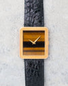 Front view of the Piaget Protocole Ref. 9154 with its striped tiger’s eye stone dial and yellow gold dauphine hands.