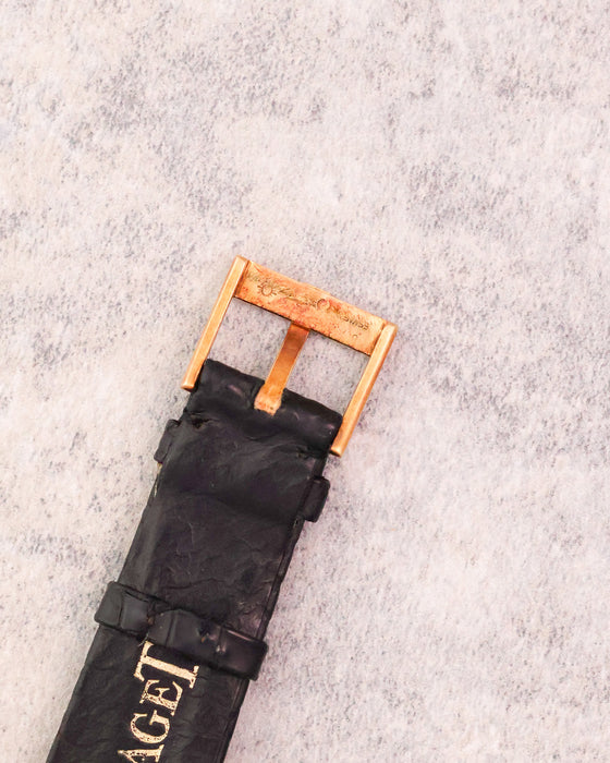 Original Piaget 18K yellow gold pin buckle fitted to the black leather strap.