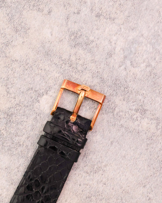 Close-up of the original Piaget 18K yellow gold pin buckle fitted to the original black leather strap.