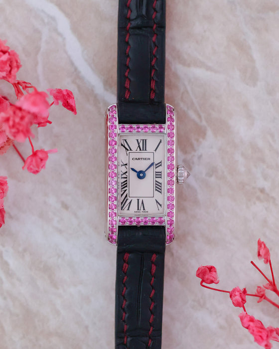 Front view of the Cartier Tank Allongée WB302831 with pink sapphire-set white gold case, Roman numeral dial and black strap.
